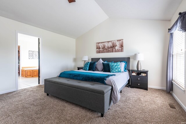 carpeted bedroom featuring multiple windows, connected bathroom, and lofted ceiling