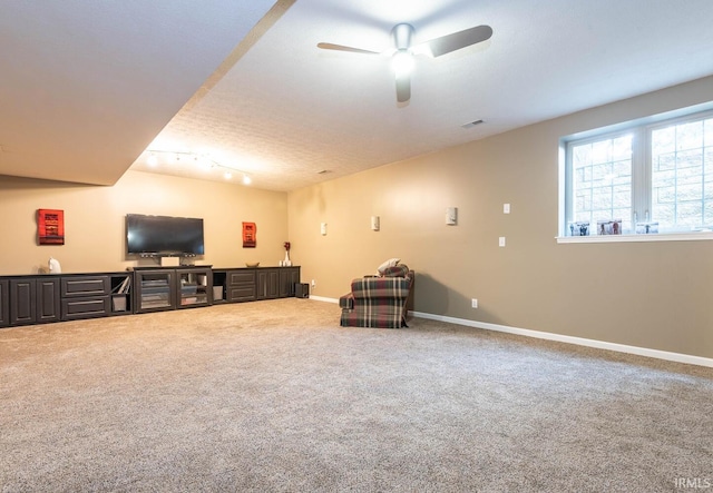 interior space featuring ceiling fan, track lighting, carpet, and a textured ceiling