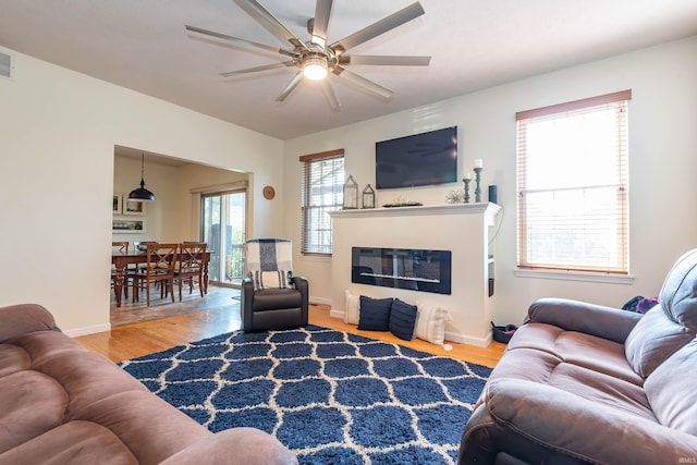 living room with wood-type flooring and ceiling fan