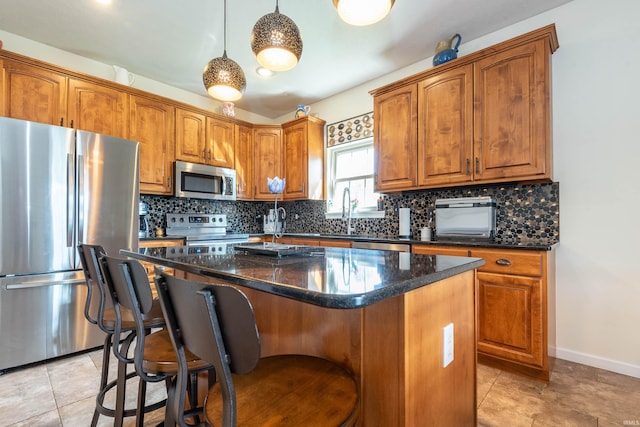 kitchen featuring pendant lighting, tasteful backsplash, stainless steel appliances, and a kitchen island