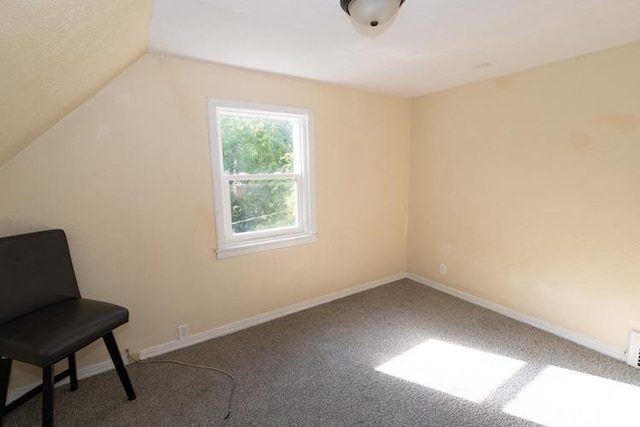 unfurnished room with lofted ceiling and carpet flooring