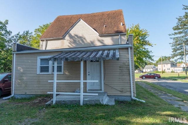 rear view of property with a lawn