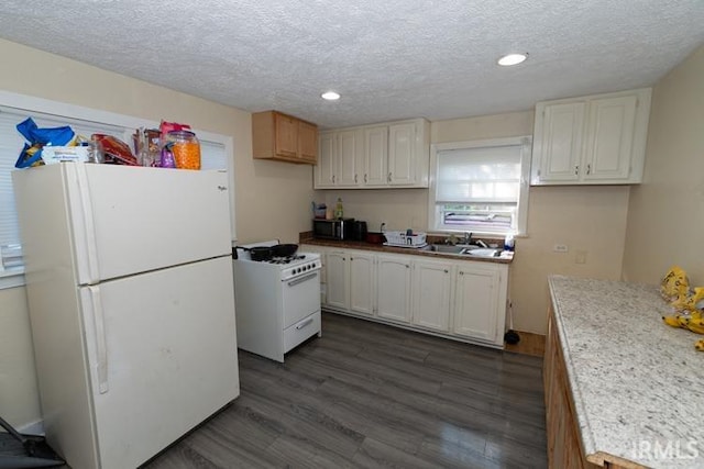 kitchen with a textured ceiling, white appliances, dark wood-type flooring, and white cabinetry