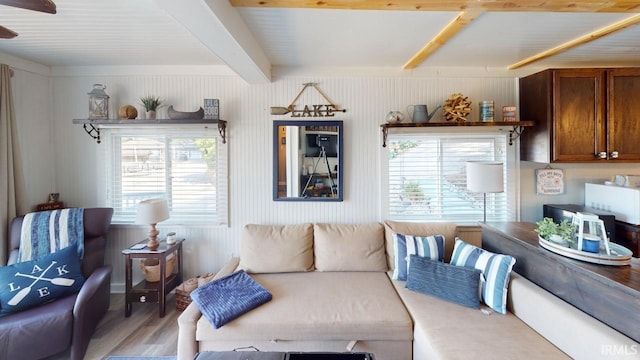 living area with light wood finished floors, beamed ceiling, and plenty of natural light