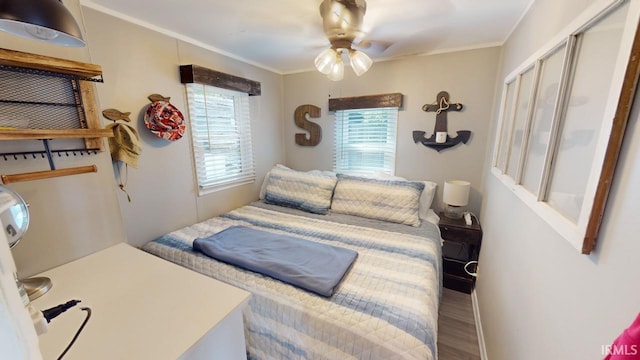 bedroom featuring ornamental molding, a closet, wood finished floors, and a ceiling fan