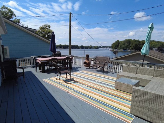 wooden deck with outdoor dining space and a water view