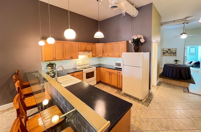 235 N Main St, Kokomo, IN 46901 - kitchen with white appliances, high vaulted ceiling, under cabinet range hood, a sink, and a peninsula