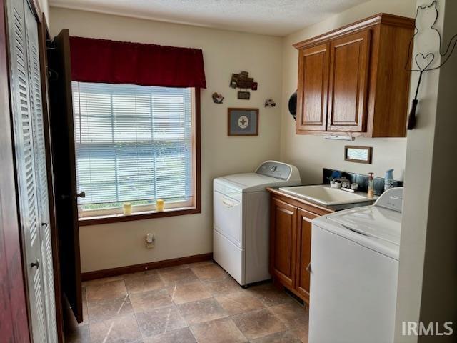 laundry area featuring sink, cabinets, and independent washer and dryer