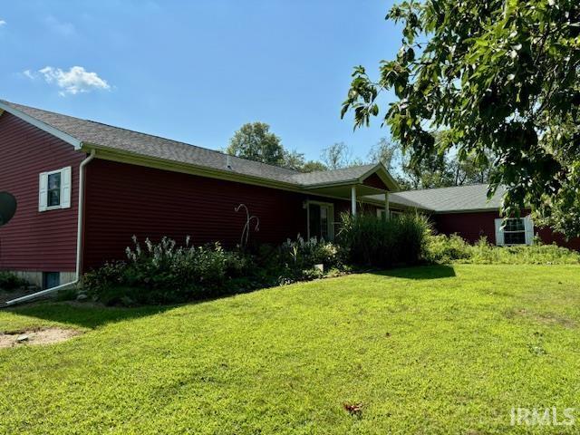 view of side of home with a yard