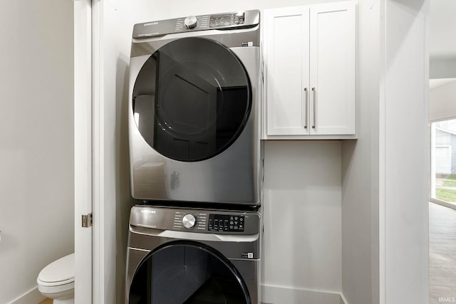 washroom with stacked washing maching and dryer