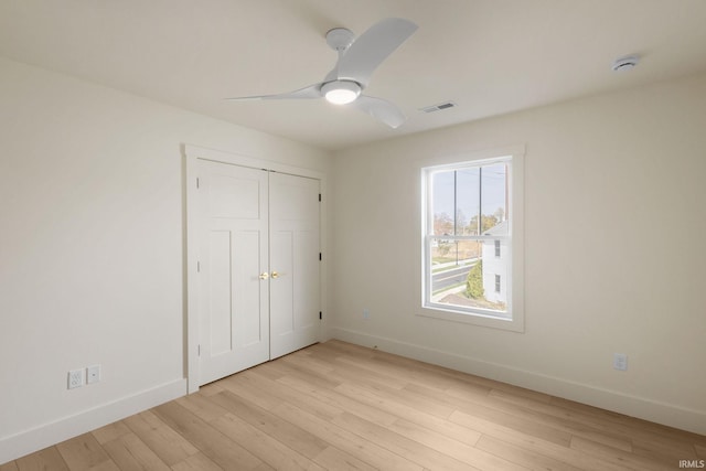 unfurnished bedroom featuring light hardwood / wood-style flooring, a closet, and ceiling fan