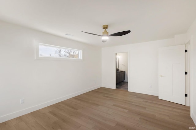 unfurnished bedroom featuring ceiling fan, ensuite bathroom, and light hardwood / wood-style floors