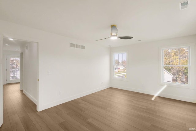 empty room with ceiling fan and light hardwood / wood-style floors