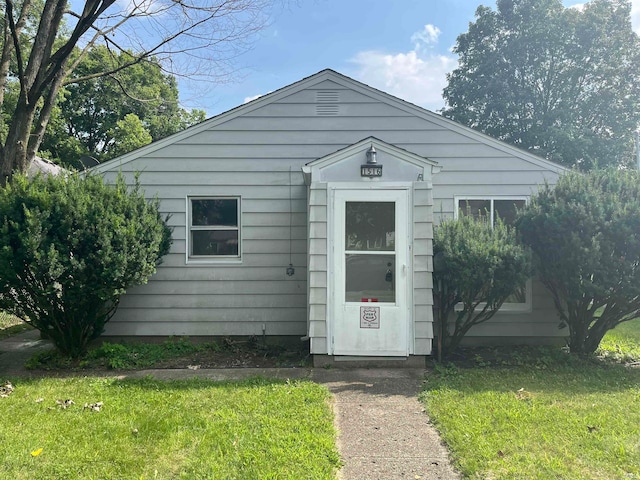 bungalow featuring a front lawn