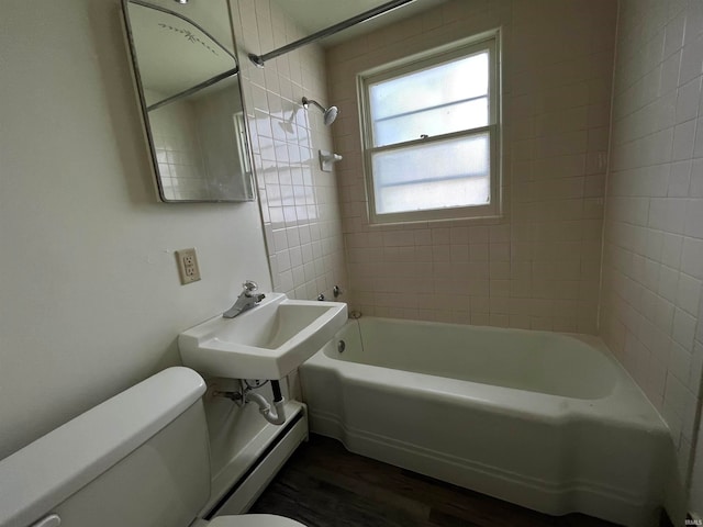 full bathroom with a baseboard heating unit, toilet, tiled shower / bath, hardwood / wood-style flooring, and sink