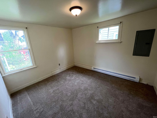 carpeted spare room featuring electric panel, a baseboard heating unit, and a wealth of natural light