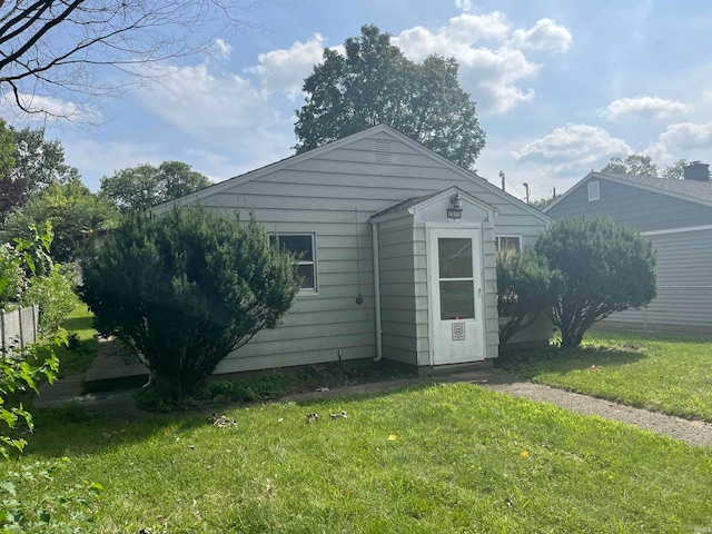 rear view of property featuring a lawn