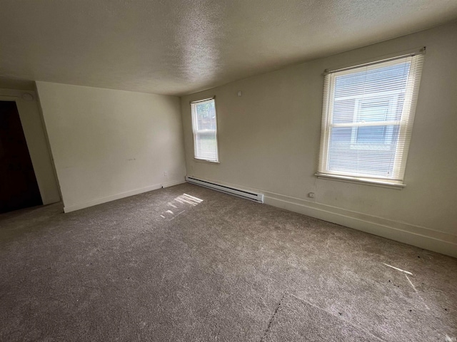 empty room with baseboard heating, a textured ceiling, and carpet