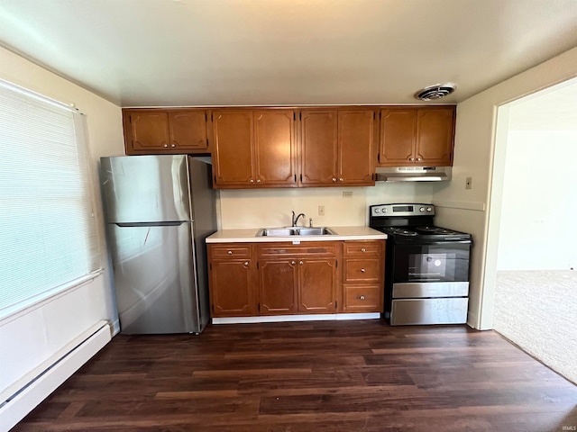 kitchen with appliances with stainless steel finishes, dark colored carpet, sink, and baseboard heating