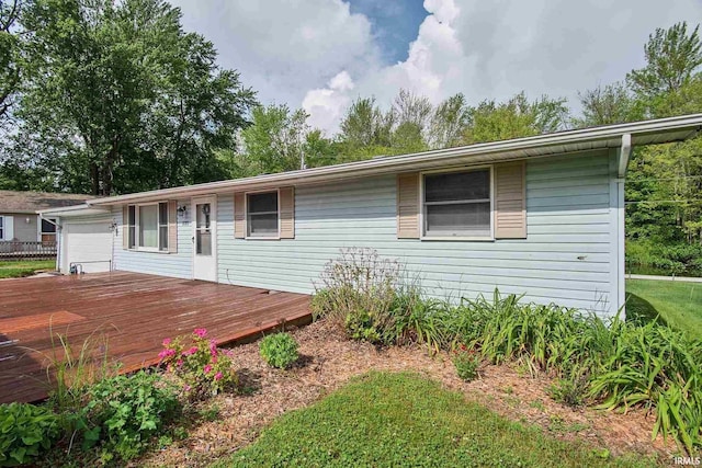 ranch-style house with a garage and a wooden deck