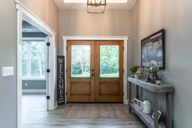 foyer entrance featuring light wood-type flooring, french doors, and a wealth of natural light