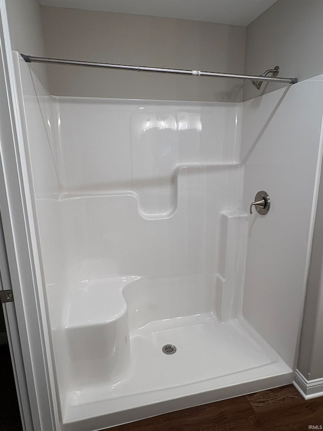 bathroom with hardwood / wood-style flooring and walk in shower