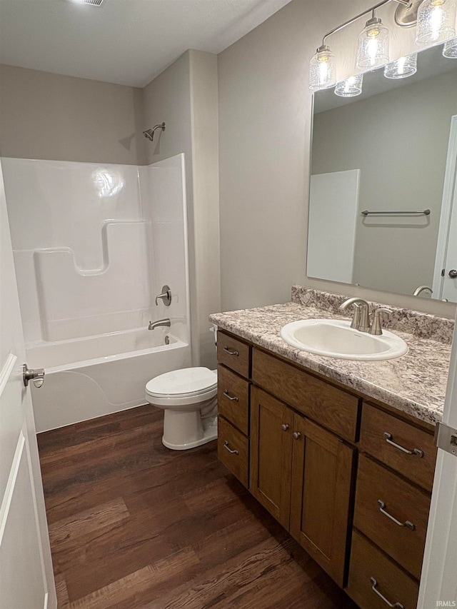 full bathroom featuring shower / washtub combination, toilet, vanity, and hardwood / wood-style flooring