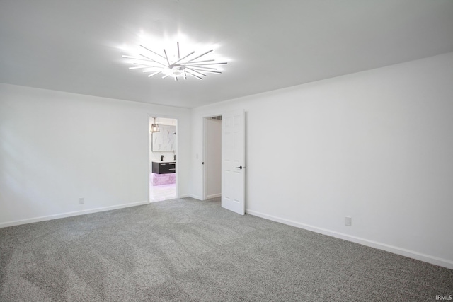 carpeted spare room with a chandelier