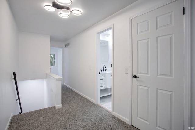 hallway featuring sink and carpet floors