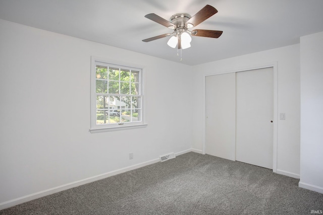 unfurnished bedroom with ceiling fan, carpet flooring, and a closet