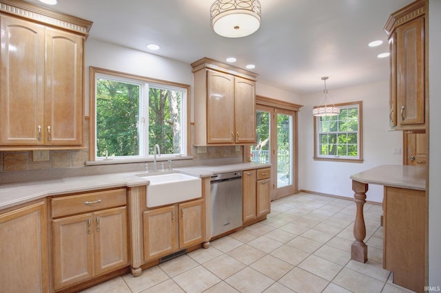 kitchen with light brown cabinets, dishwasher, light tile patterned flooring, decorative light fixtures, and sink