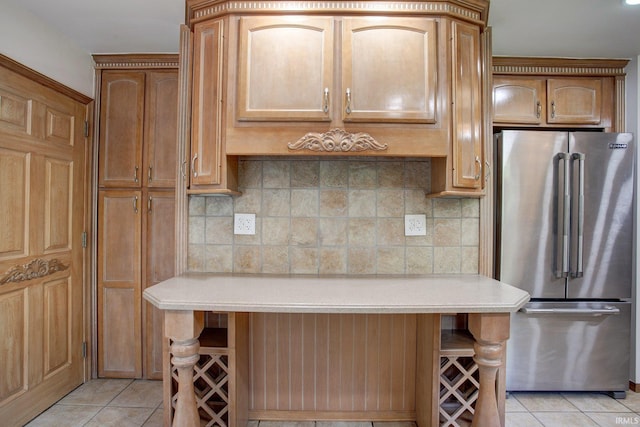 kitchen featuring light tile patterned flooring, tasteful backsplash, and high end refrigerator