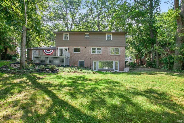 back of house featuring a lawn and a deck