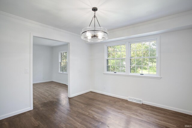 empty room featuring crown molding, hardwood / wood-style floors, and a chandelier