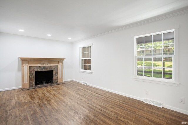 unfurnished living room with a fireplace, wood-type flooring, and ornamental molding