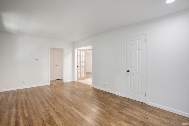 empty room featuring crown molding and hardwood / wood-style flooring