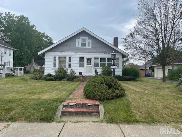 bungalow-style house featuring a front lawn and a garage