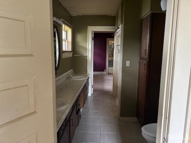 bathroom featuring double vanity, tile patterned flooring, and toilet