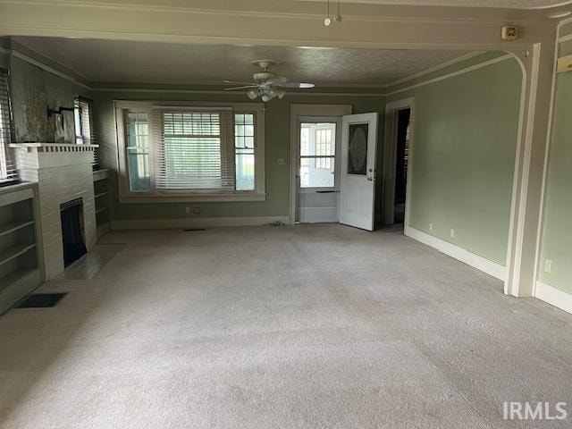 unfurnished living room with ceiling fan, ornamental molding, and light colored carpet