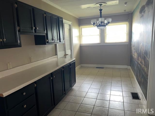 kitchen featuring light tile patterned floors, a chandelier, pendant lighting, and ornamental molding