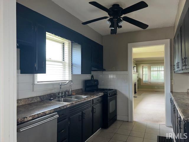 kitchen featuring light tile patterned flooring, black range, dishwasher, ceiling fan, and sink