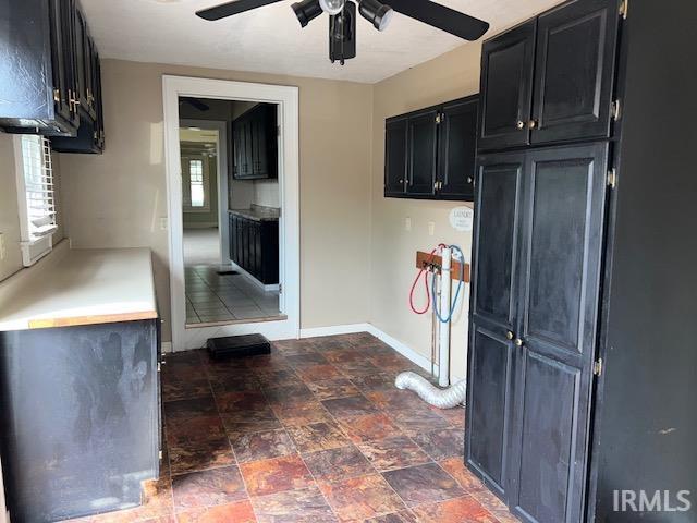 kitchen with ceiling fan and dark tile patterned flooring