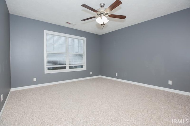 unfurnished room featuring carpet flooring, visible vents, baseboards, and a ceiling fan