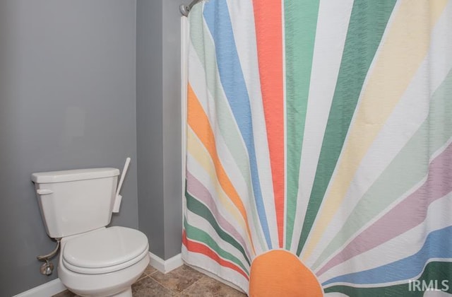 full bathroom featuring tile patterned floors, baseboards, and toilet