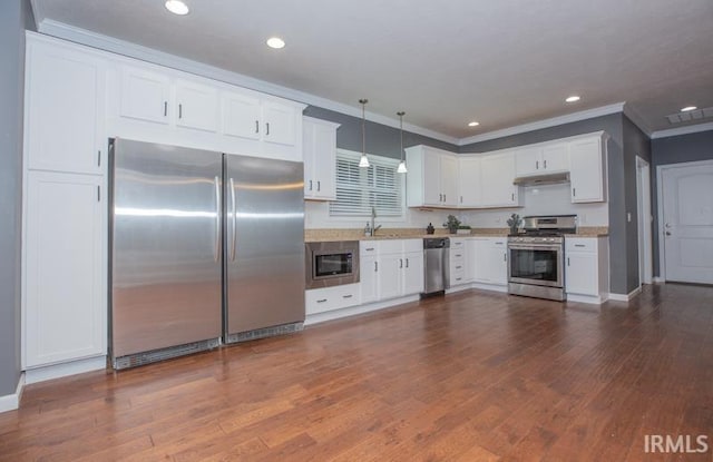 kitchen with white cabinets, a sink, dark wood finished floors, under cabinet range hood, and stainless steel appliances