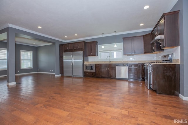 kitchen with hardwood / wood-style flooring, pendant lighting, and appliances with stainless steel finishes