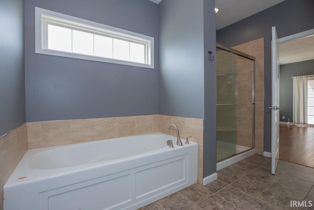 bathroom with a bath, a shower stall, tile patterned flooring, and a healthy amount of sunlight