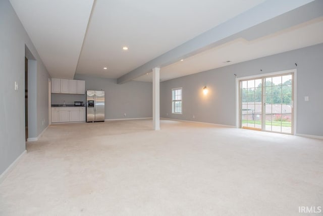 unfurnished living room featuring light carpet