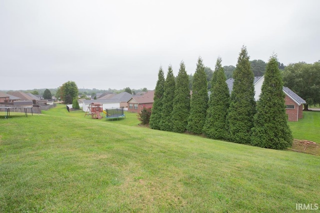 view of yard featuring a playground and a trampoline