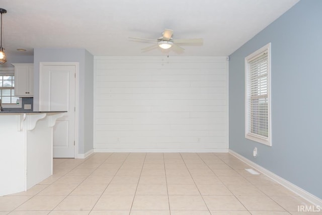 tiled empty room featuring ceiling fan